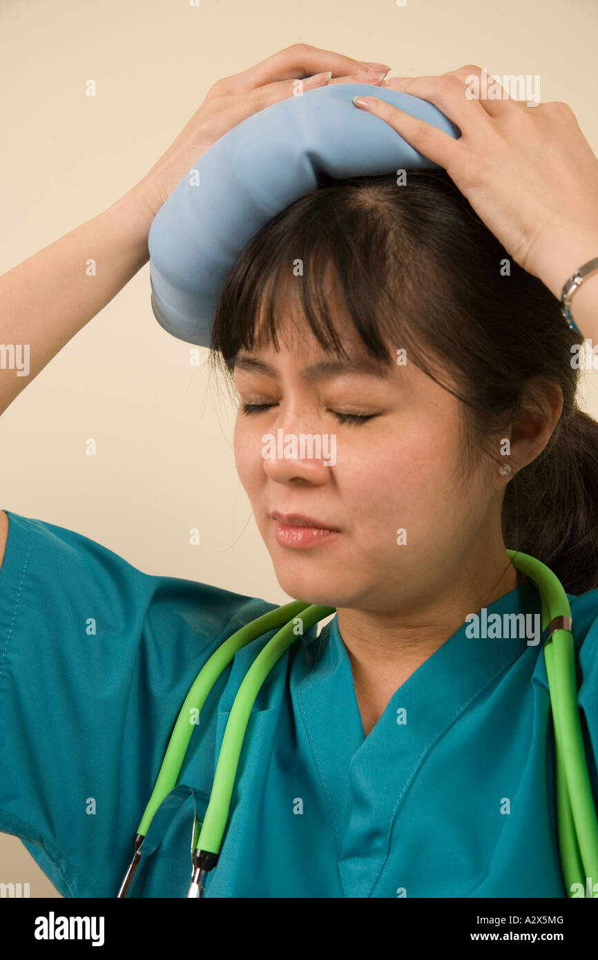 L'infermiera ha una giornata stressante. Ora lei ha un mal di testa. Foto Stock