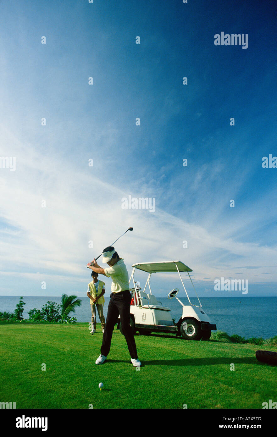Filippine. L'uomo giocando a golf sul campo da golf costiere corso. Foto Stock