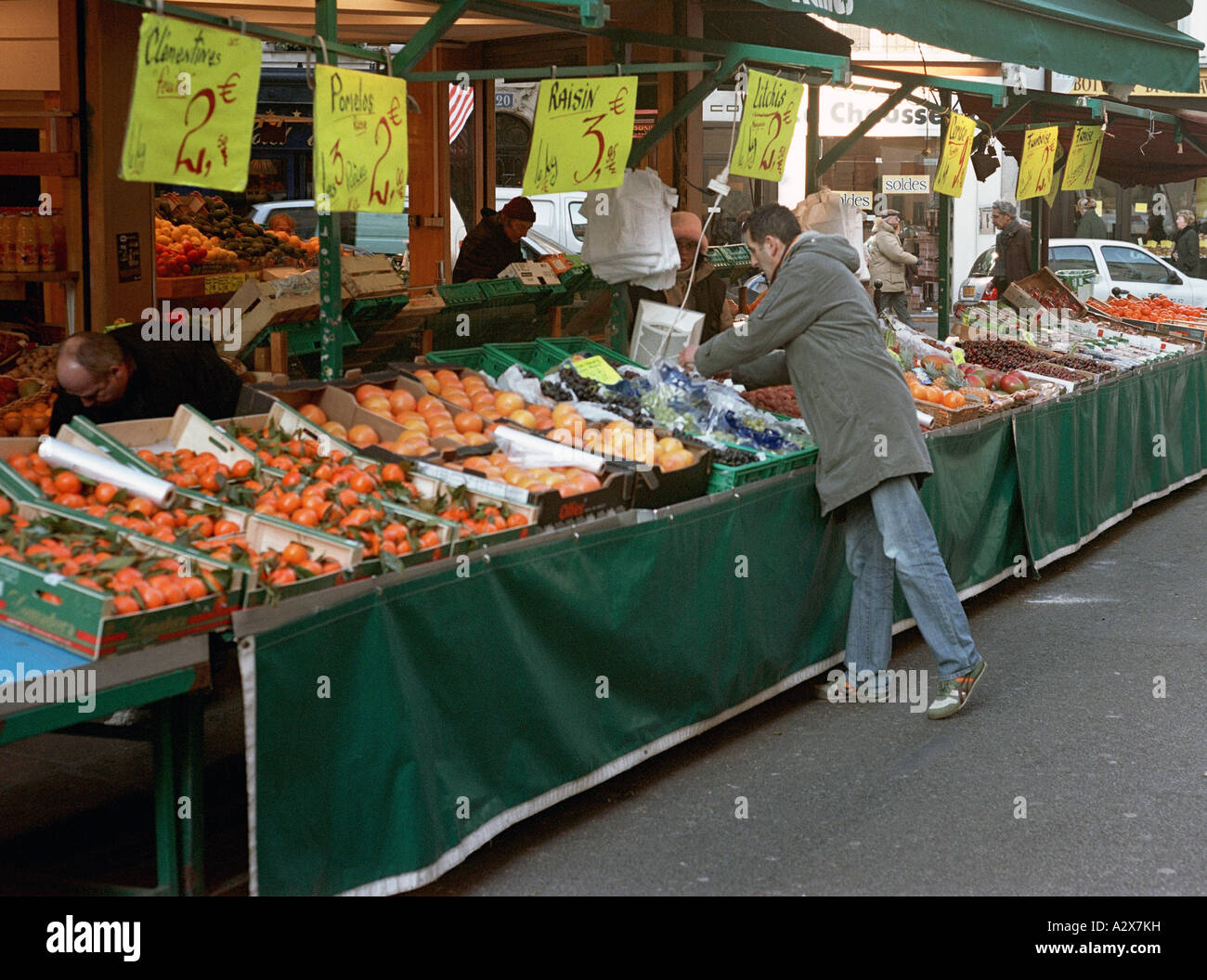 Un venditore prepara il suo stallo per azienda in un mercato aperto nel quinto arrondissement Foto Stock