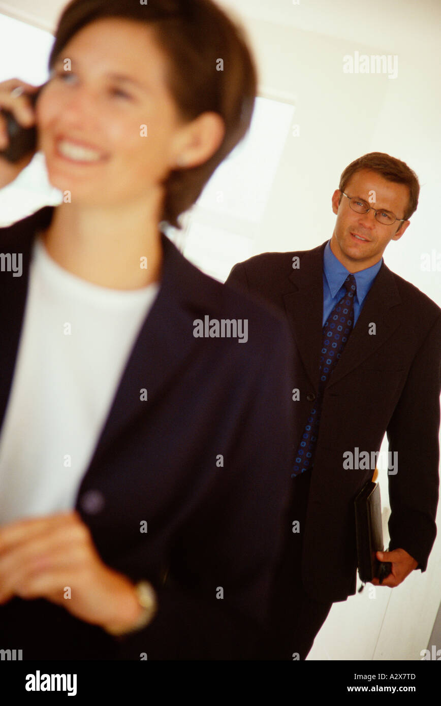 Giovane uomo e donna i dirigenti aziendali in piedi all'interno. Foto Stock
