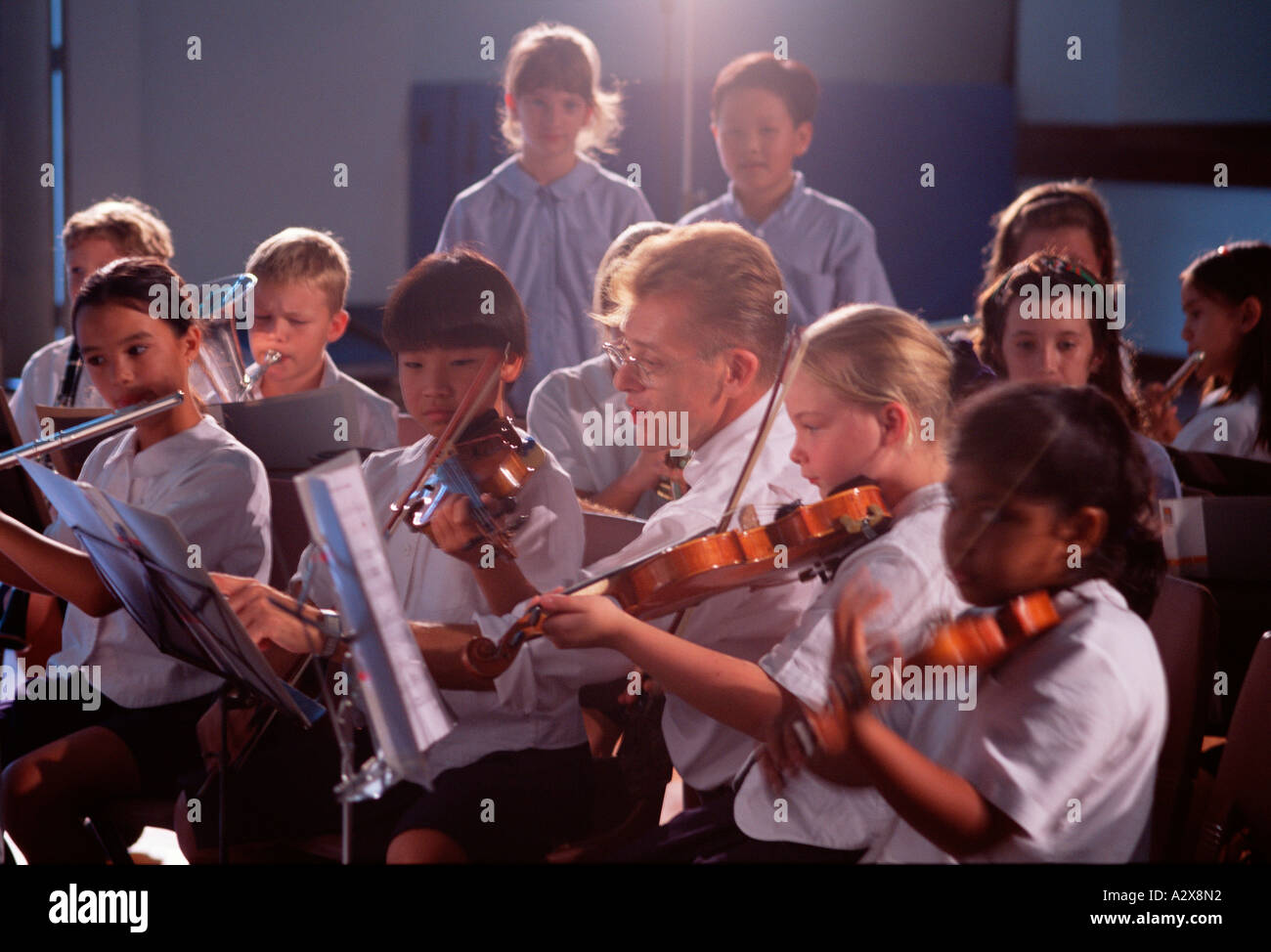 Insegnante di scuola e orchestra di bambini lezione di musica. Foto Stock