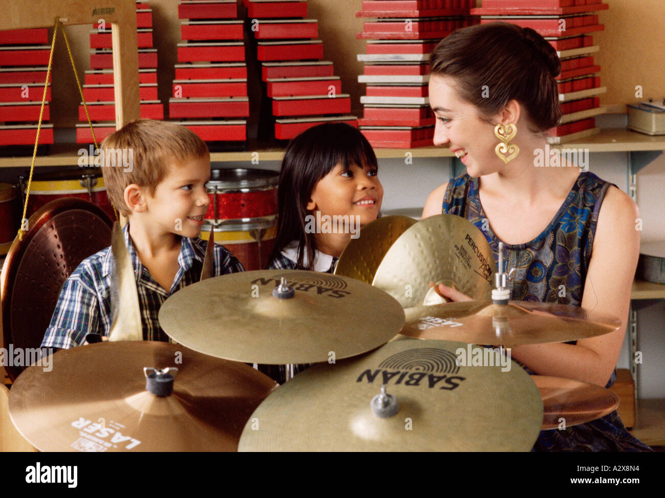 Piscina closeup dell insegnante e due bambini di scuola gli studenti di percussioni lezione di musica. Foto Stock