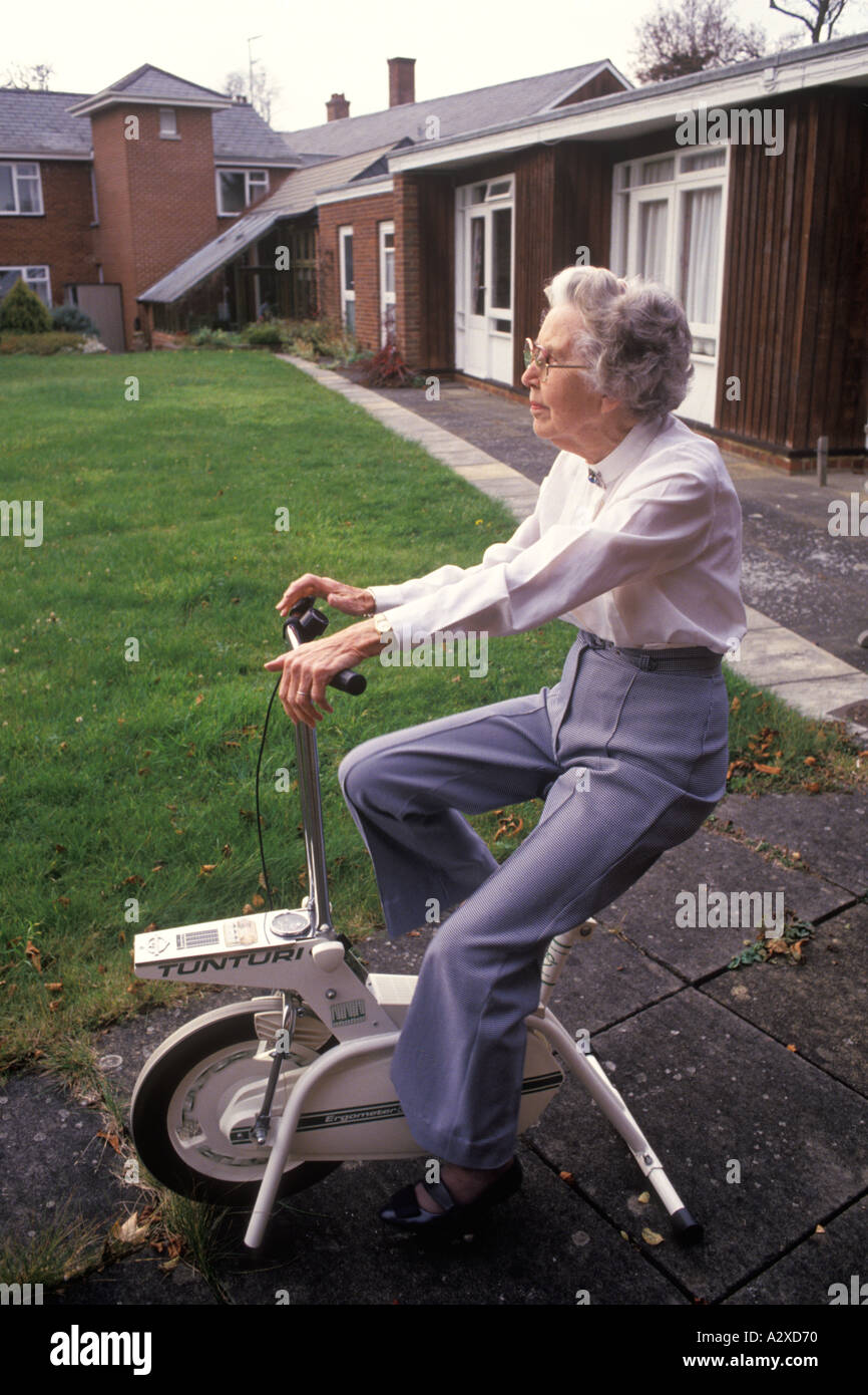 Donna anziana sulla cyclette nei giardini di una vecchia casa la gente  Cirencester Gloucestershire Inghilterra HOMER SYKES Foto stock - Alamy