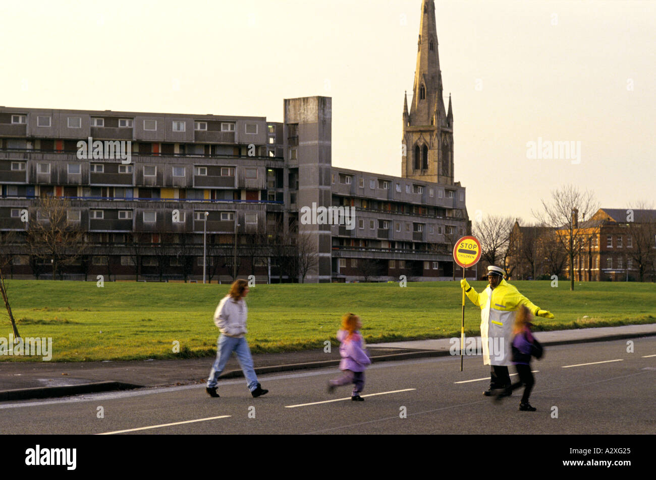 Un "lecca-lecca" LADY STREET WARDEN bloccano il traffico per consentire alle persone di attraversare la strada in,MOSS SIDE, Manchester,1993 Foto Stock