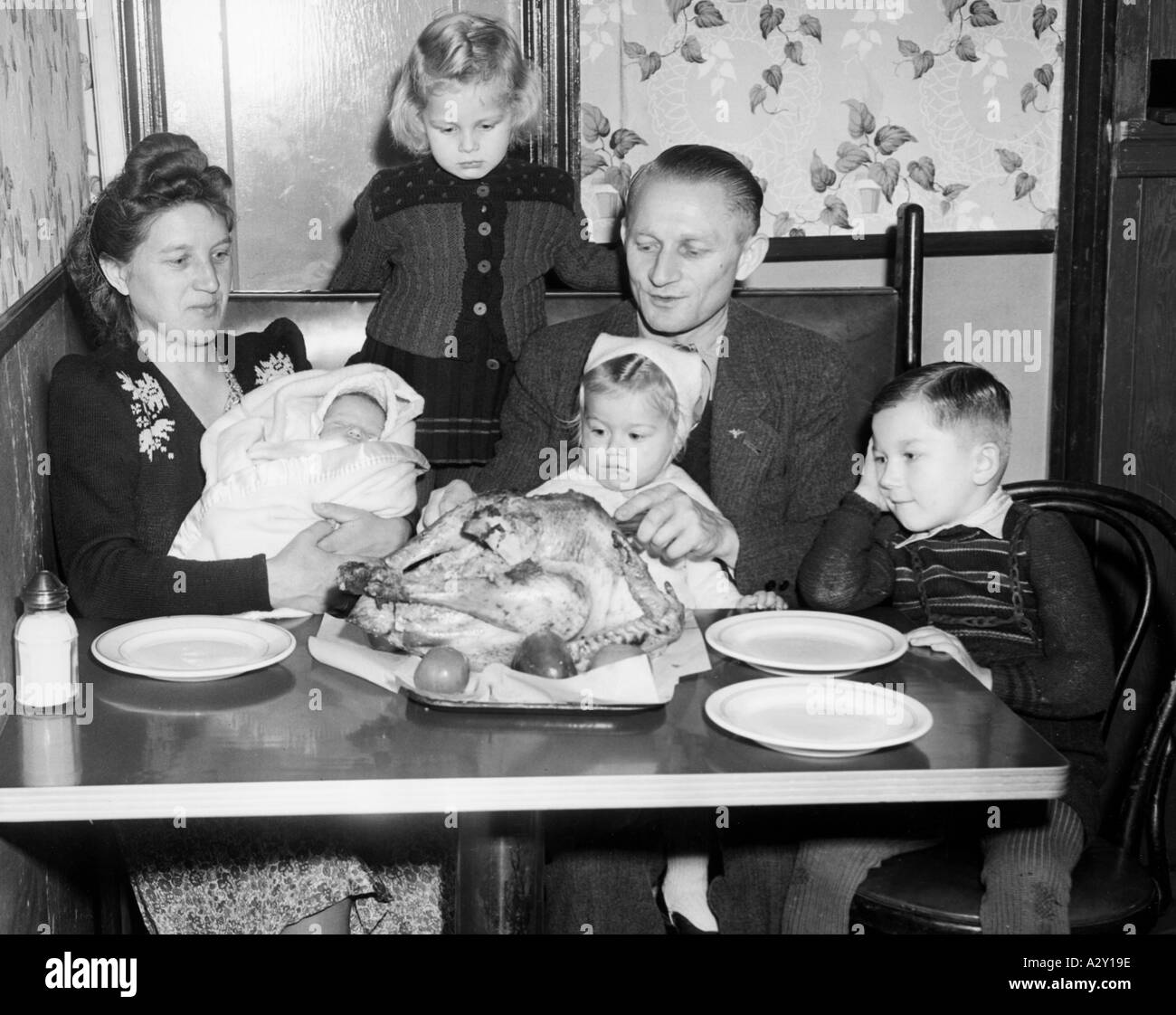 Questi rifugiati polacchi hanno celebrato il loro primo Ringraziamento negli Stati Uniti mentre erano in transito a New York nel 1949 baby era nato sull'aereo sopra l'Atlantico, la famiglia intendeva procedere per l'Illinois il successivo mese in cui il padre stava andando a lavorare in una fattoria Das erste Erntedankfest in den USA erleben diese polnischen Kriegsfluechtlinge 1949 auf der Durchreise a New York Ihr Baby kam auf dem Flug ueber den Atlantik zur Welt IM Dezember morirà Familie nach Illinois ziehen Wo der Vater auf einer Farm arbeiten Wird Curious Moments S 511 Foto Stock