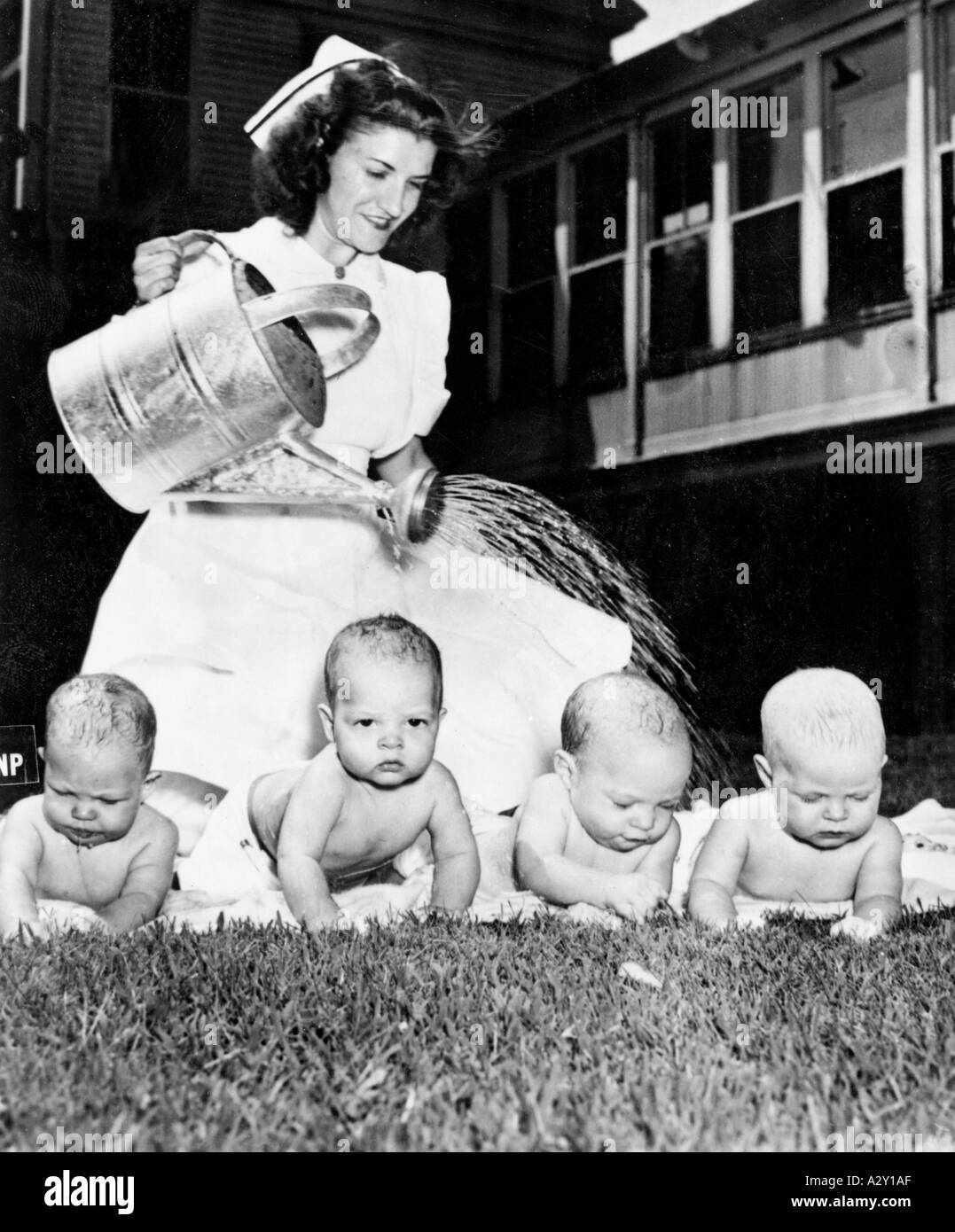 È stata l'ondata di caldo nell'estate del 1947 a Baltimora o è stato il fotografo che ha persuaso i bambini s infermiera Virginia McCormick di St Agnes Hospital per impiegare questa insolita forma di assistenza infermieristica in ogni caso il i quadrupletti sono visibilmente impressionati IST es die Hitzewille a Baltimore im Sommer 1947 oder der Fotograf der die Kinderkrankenschwester Virginia McCormick im St Agnes Hospital zu ungewoehnlichen Pflegemassnahmen verleitet die Vierlinge lassen die Berieselung unbeteiligt ueber sich ergehen momenti curiosi S 527 Foto Stock