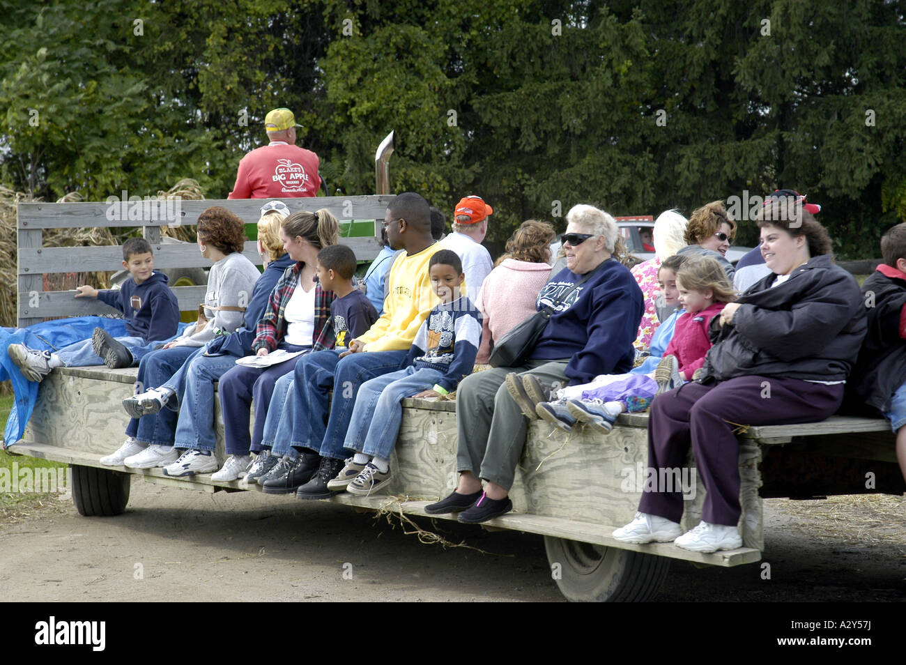 Famiglie ride su un carro di fieno in una zucca patch durante il periodo autunnale per il divertimento e il piacere Foto Stock