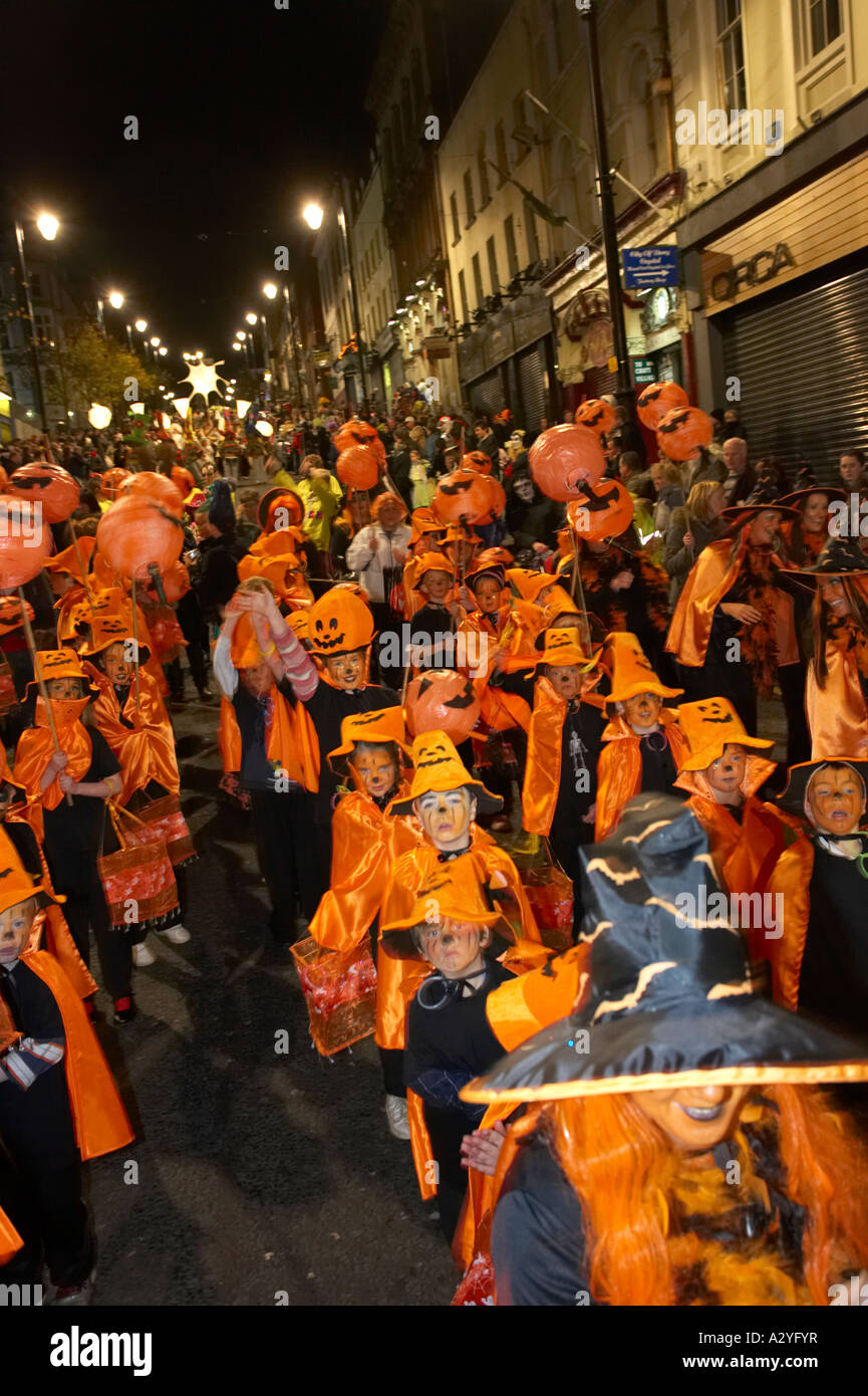 Scolari e insegnanti vestito come zucche arancione parade giù shipquay street Halloween Derry Irlanda Foto Stock