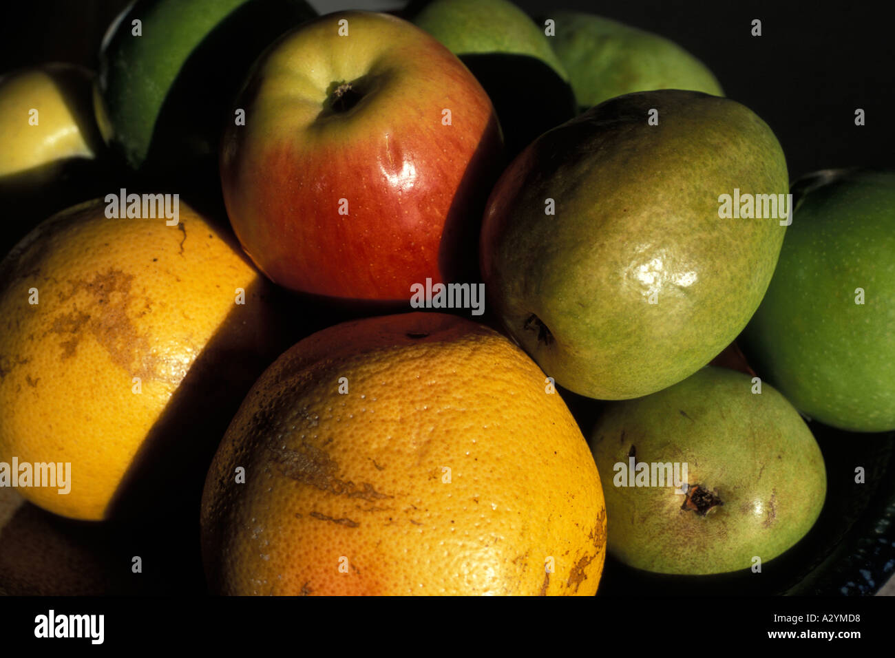 Arance e mele in una coppa di frutta con la luce del tramonto su di essi Foto Stock