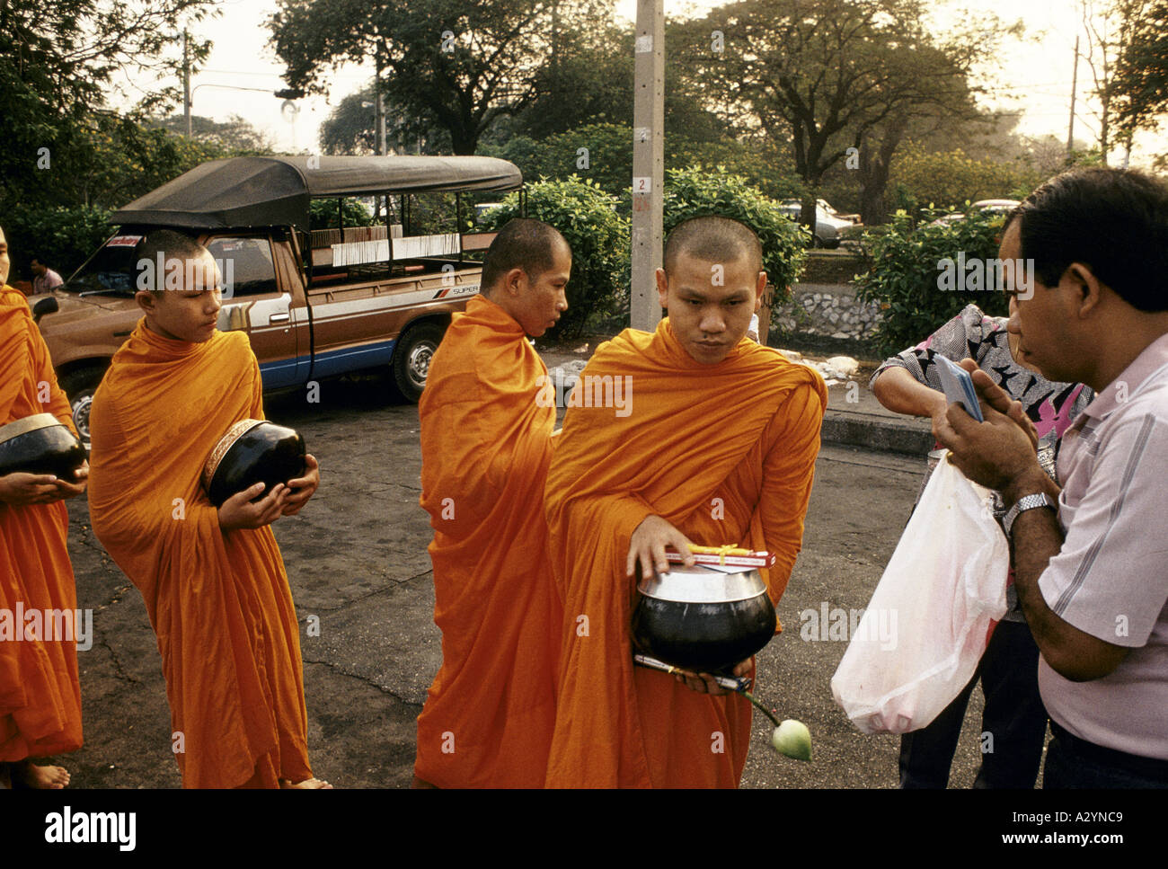 I monaci buddisti ricevendo alms a Alba al di fuori di Wat Benjamabopit a Bangkok, in Thailandia Foto Stock
