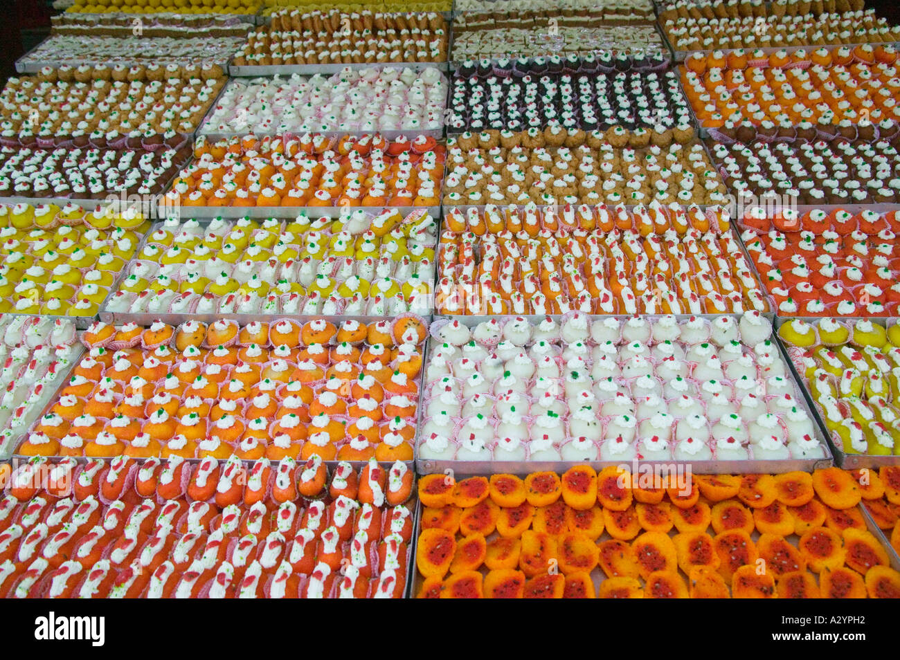 La vendita di colorate torte dolci al mercato Agra India Foto Stock