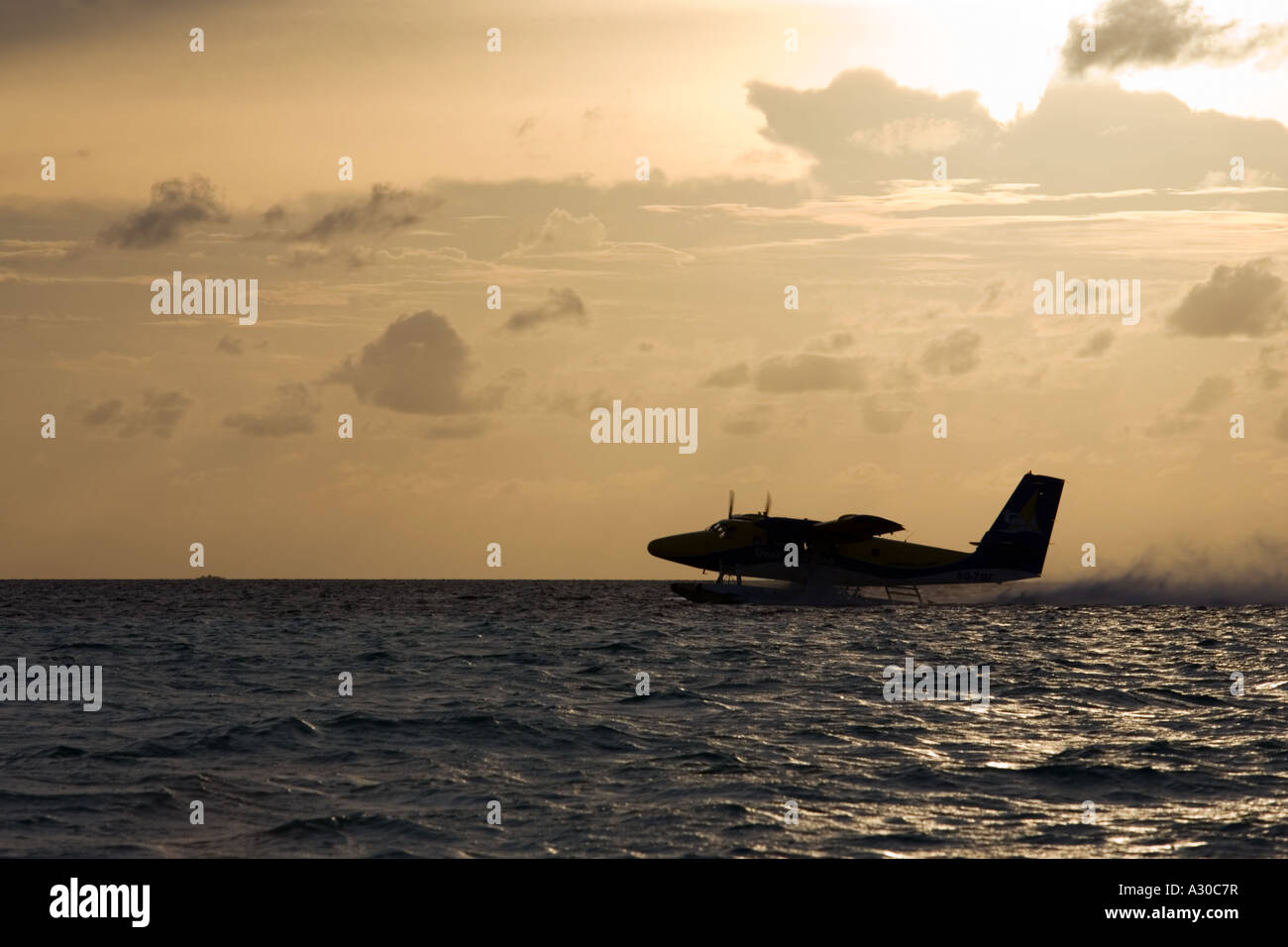 Piano dell'acqua (taxi) prendendo il largo nelle Maldive al crepuscolo Foto Stock