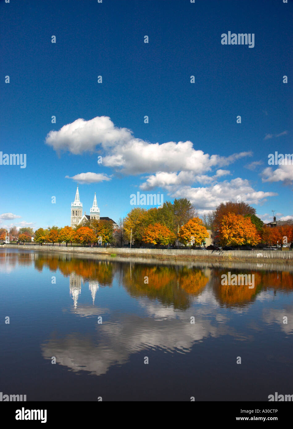 Il twin spired chiesa a Farnham in Estrie Quebec riflessa nel fiume Yamaska Foto Stock