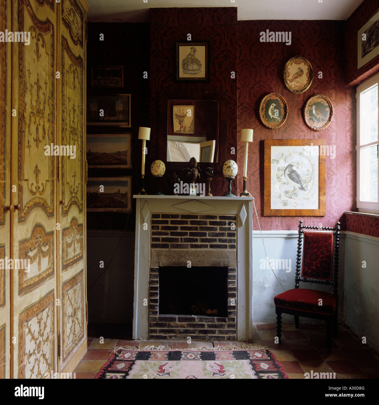 Sedia al caminetto in mattoni in camera con armadio dipinto Foto Stock