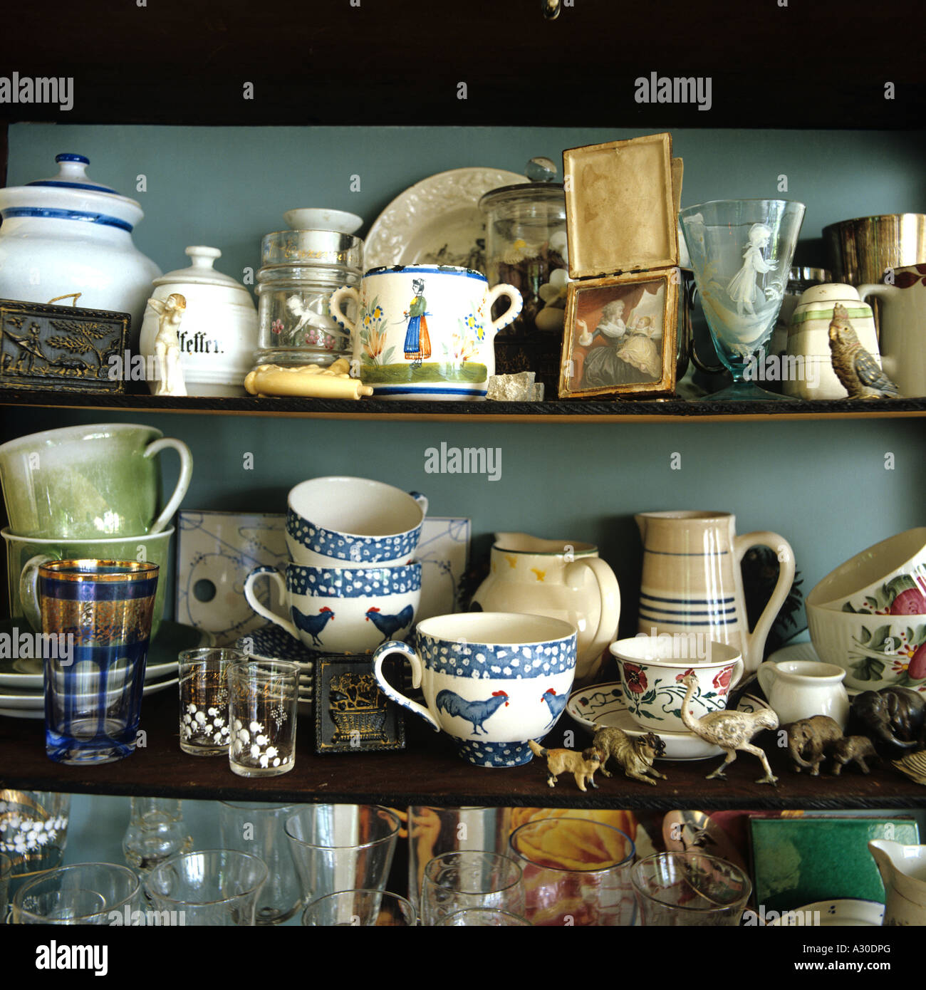 Assortimento di stoviglie e tazze sul ripiano in cucina di paese Foto Stock