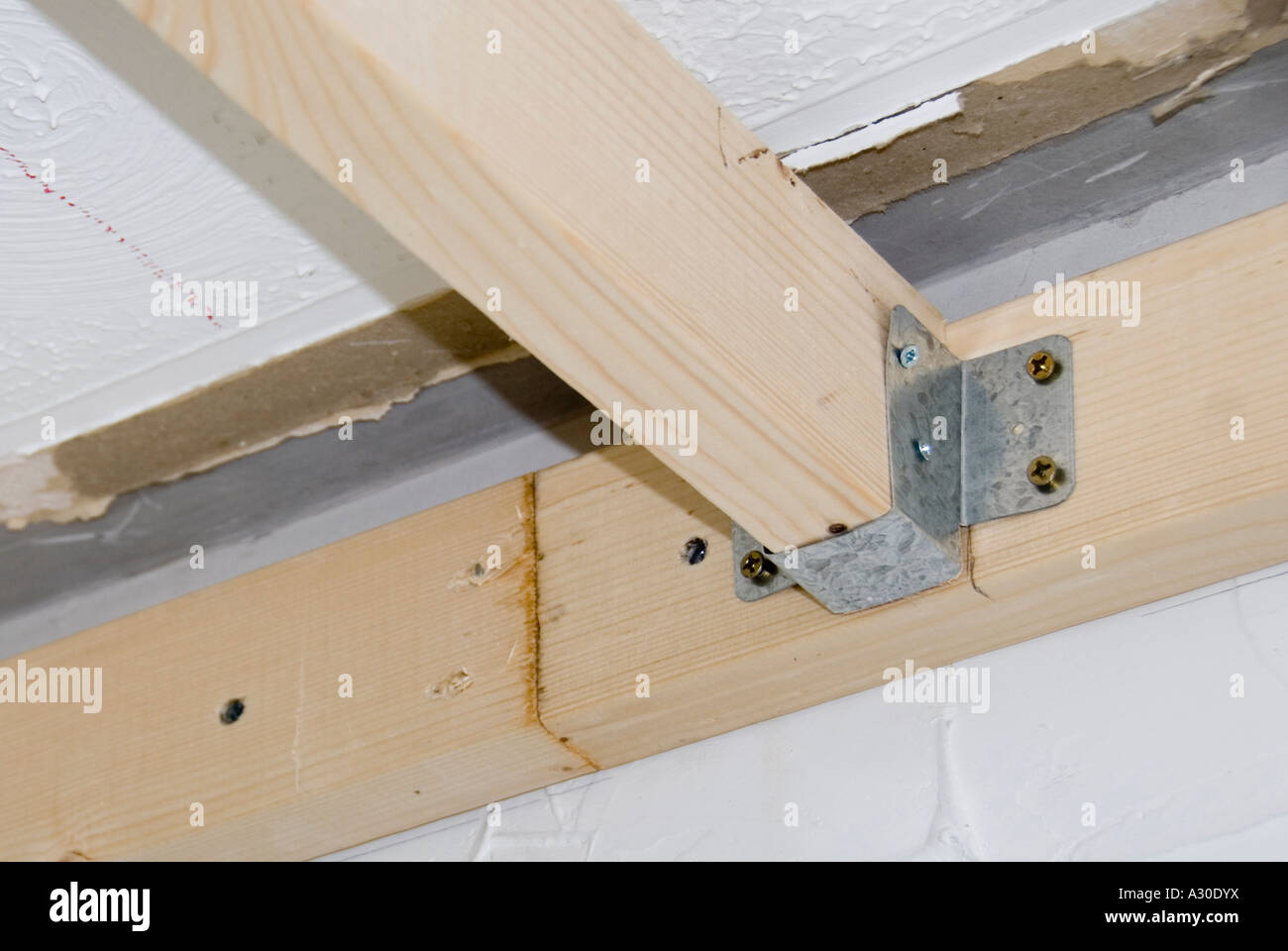 In acciaio zincato stampato la staffa di metallo utilizzato per rendere la falegnameria giunto tra travi del soffitto e piastra a parete per interni home improvement alterazioni REGNO UNITO Foto Stock
