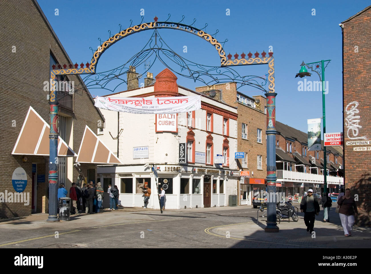 Street Scene & Banglatown Arch nel cuore della comunità bengalese segna l'ingresso alla gente di Brick Lane allo Spitalfields Health Centre East London UK Foto Stock