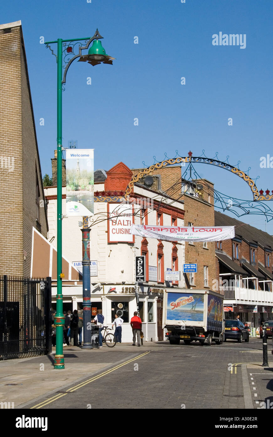 Street Scene & Banglatown Arch nel cuore della comunità bengalese segna l'ingresso alla gente di Brick Lane allo Spitalfields Health Centre East London UK Foto Stock