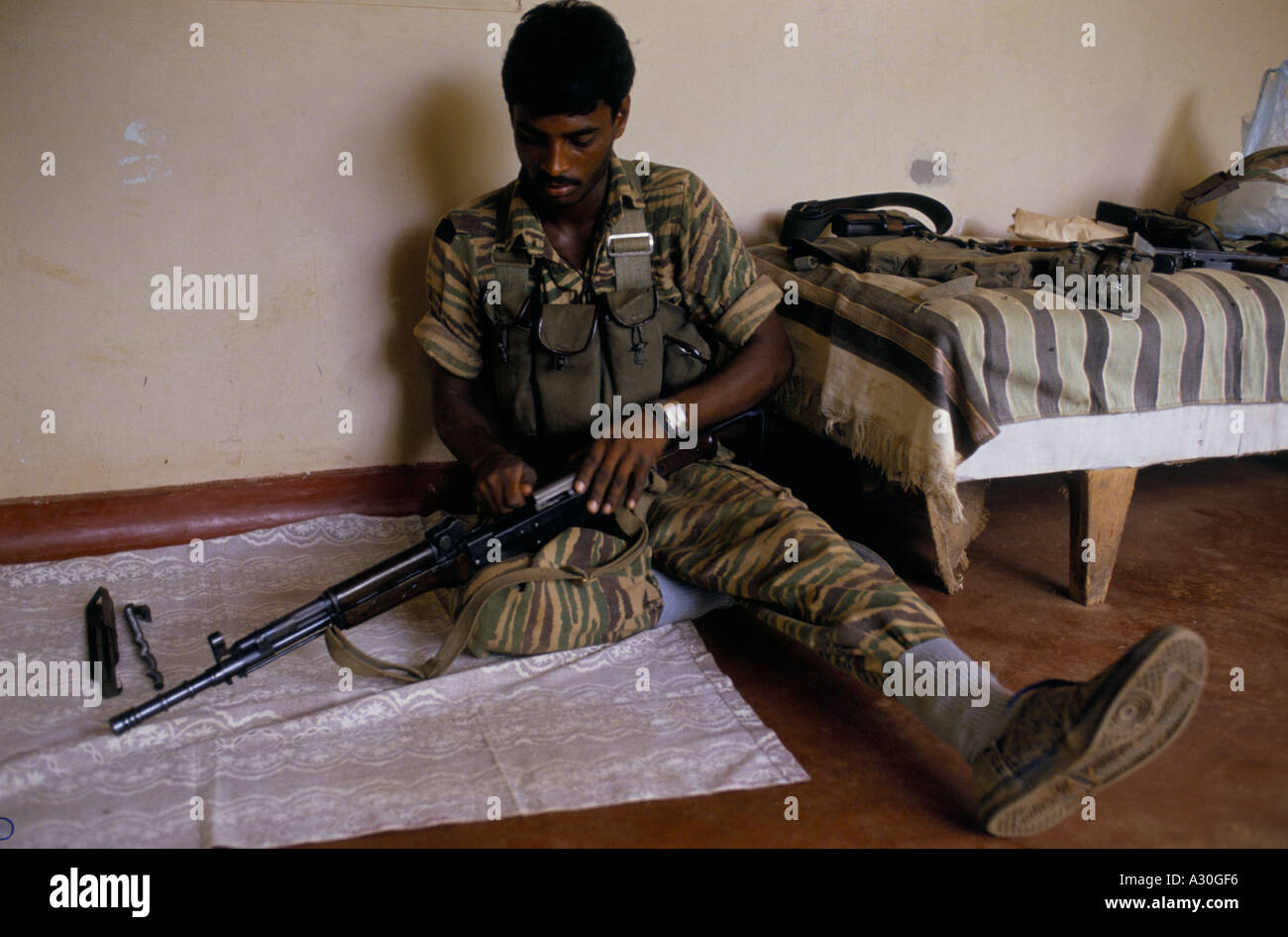 Il Tamil tiger pulizia soldato il suo fucile in caserma a Jaffna nello Sri Lanka Foto Stock