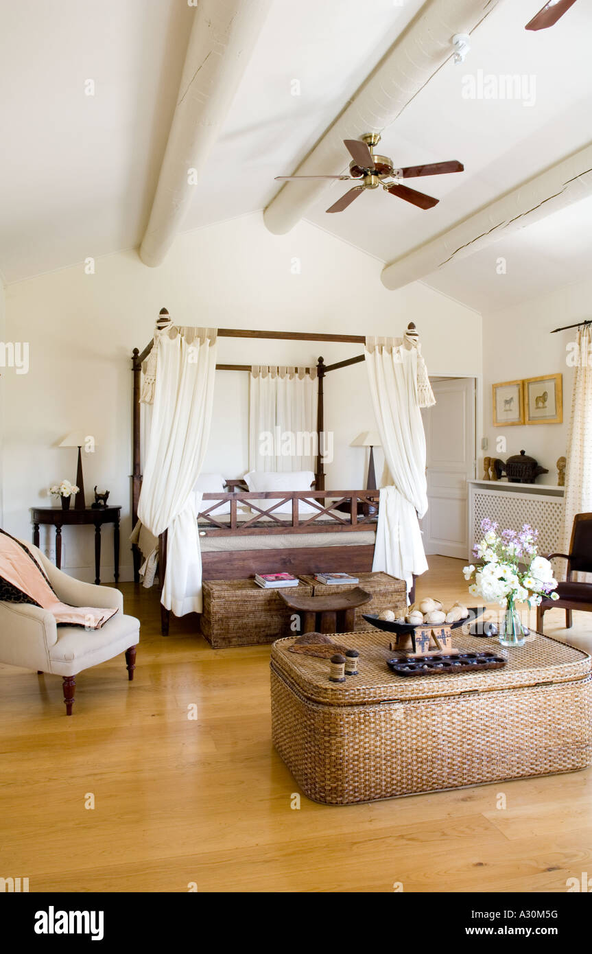 Camera da letto con lo storage di vimini torace, letto a baldacchino e un ventilatore a soffitto Foto Stock