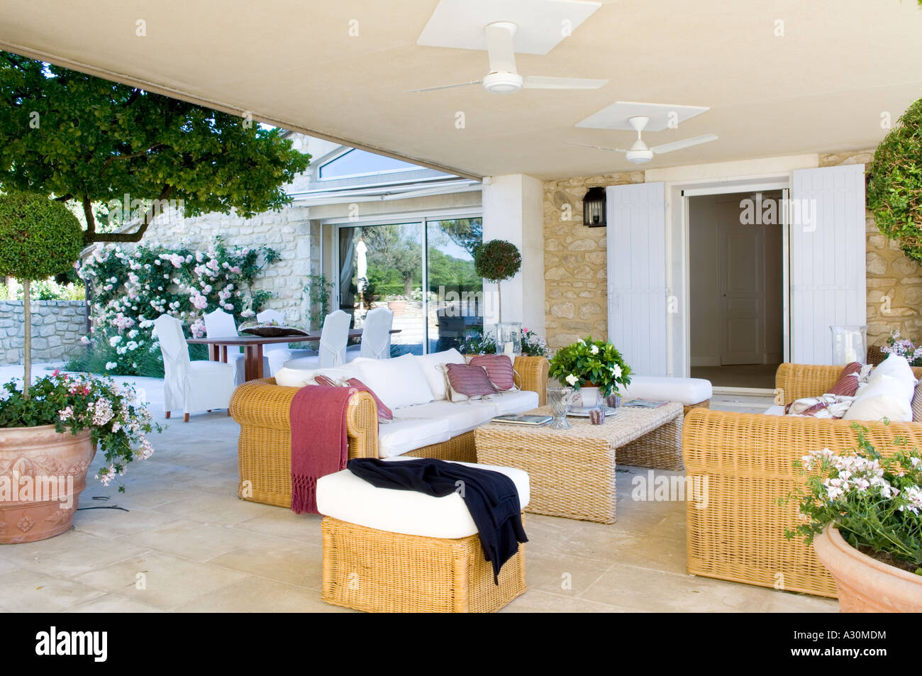 Terrazzo esterno con mobili in vimini e ventilatori a soffitto Foto Stock