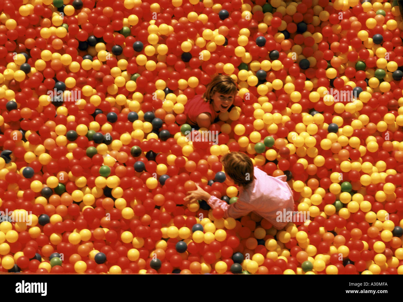 Bambini che giocano a palla di plastica pit Foto Stock