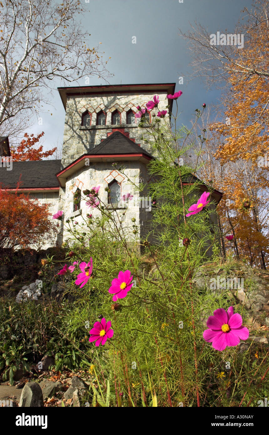 Fiori di colore rosa nella parte anteriore di una cappella nel giardino del monastero Abbaye de St Benoit de Lac in Estrie, Québec Foto Stock