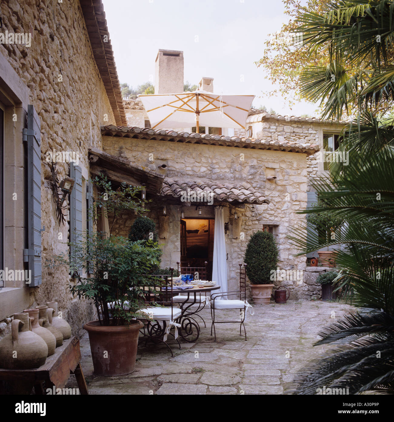 Pavimentato cortile terrazza con tavolo e sedie di pietra provenzale villa Foto Stock