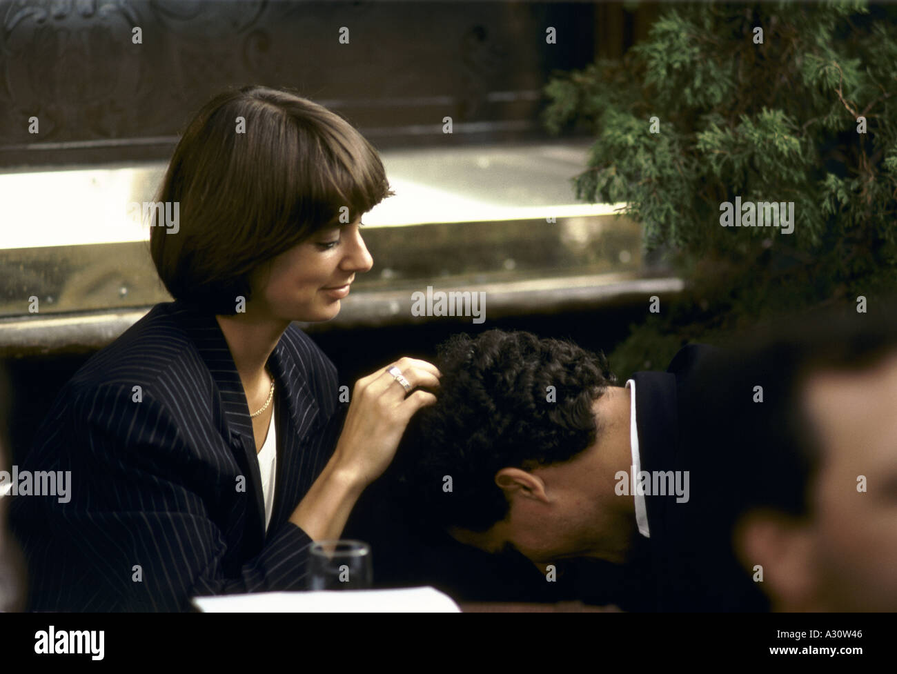 Donna che guarda in un mans capelli Foto Stock