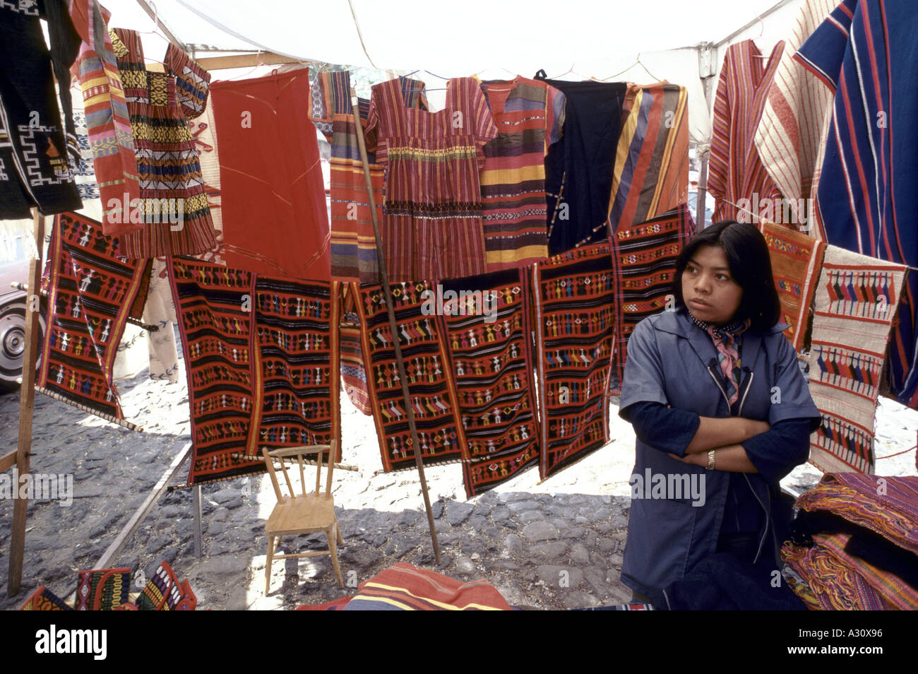 Donna che vendono vestiti e tappeti su un mercato in stallo il Messico Foto Stock