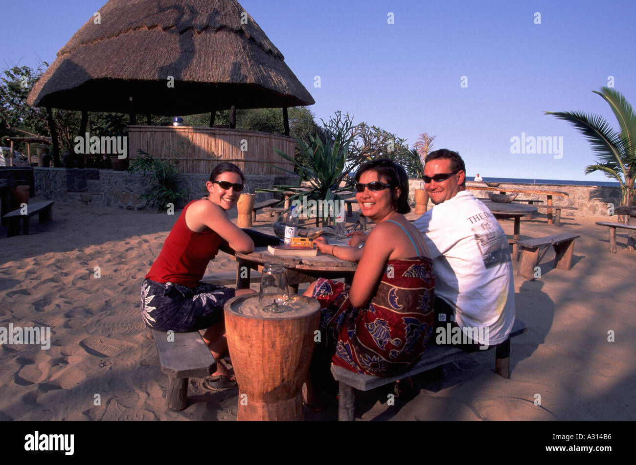 Turisti che si godono un bar sulla spiaggia sul lago Malawi Foto Stock