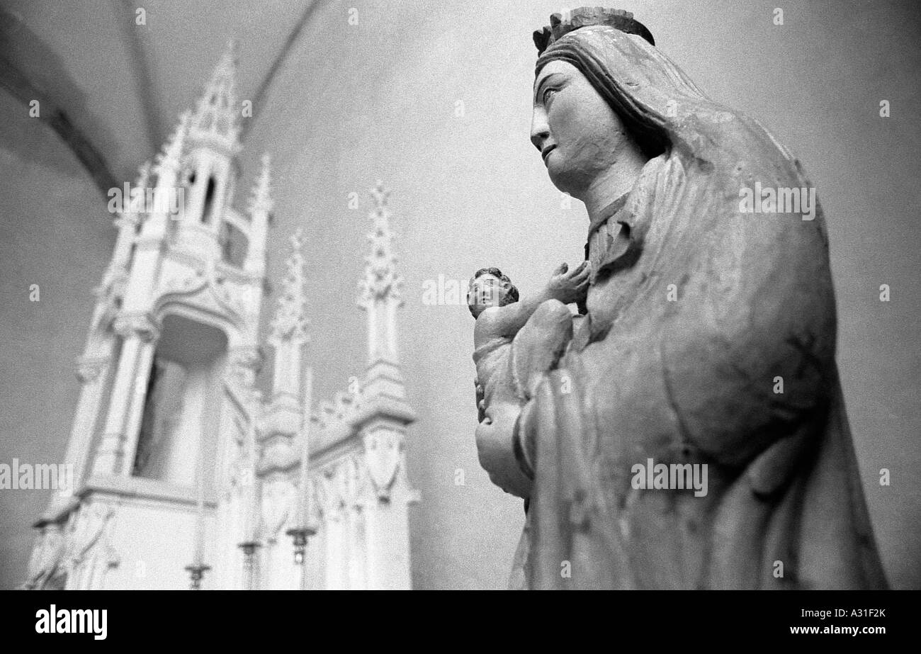 Statua di Maria Maddalena che tiene il bambino Gesù in una chiesa in monocromia Foto Stock