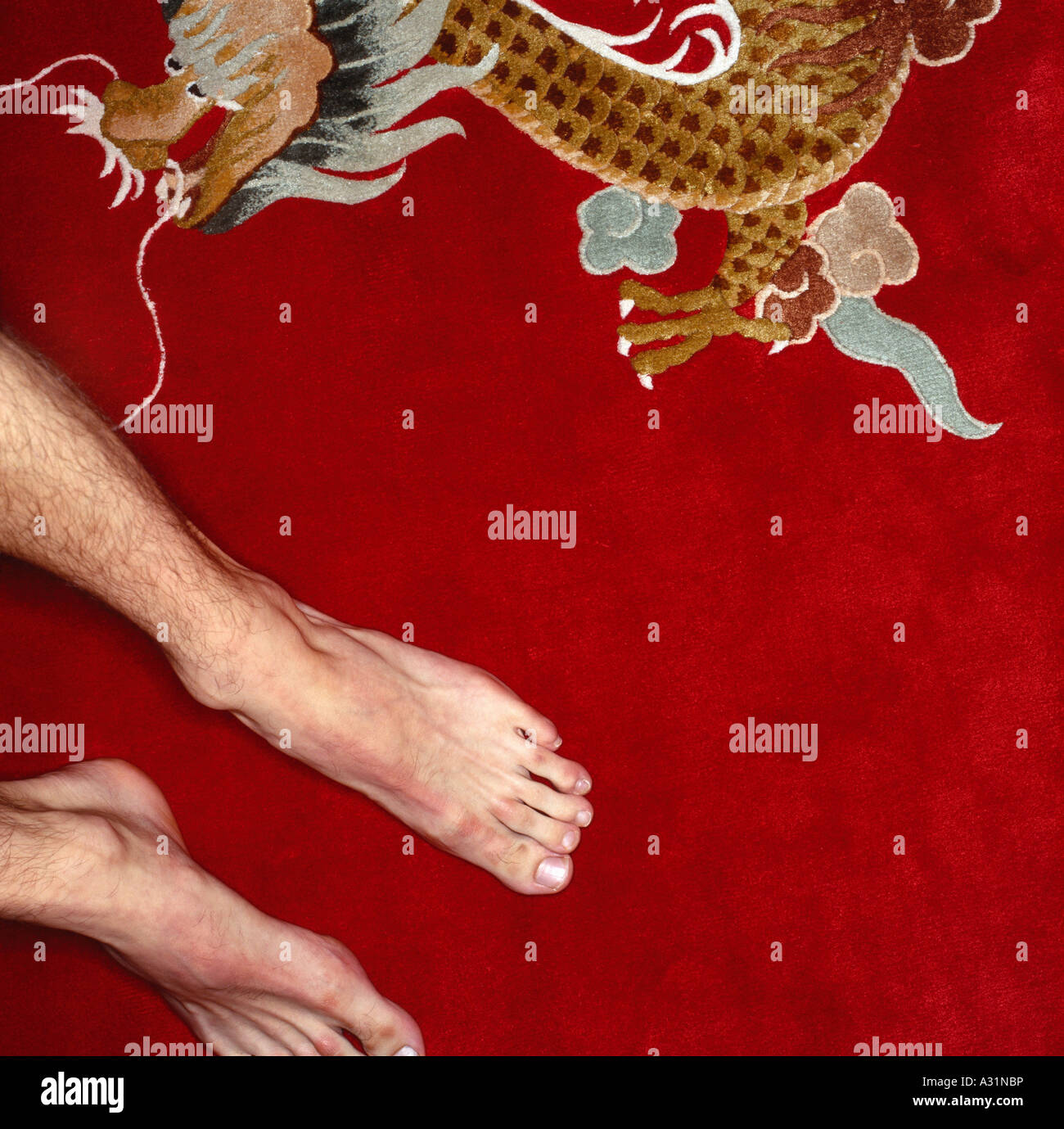 Uomo di piedini di appoggio sul tappeto rosso con il simbolo del drago Foto Stock