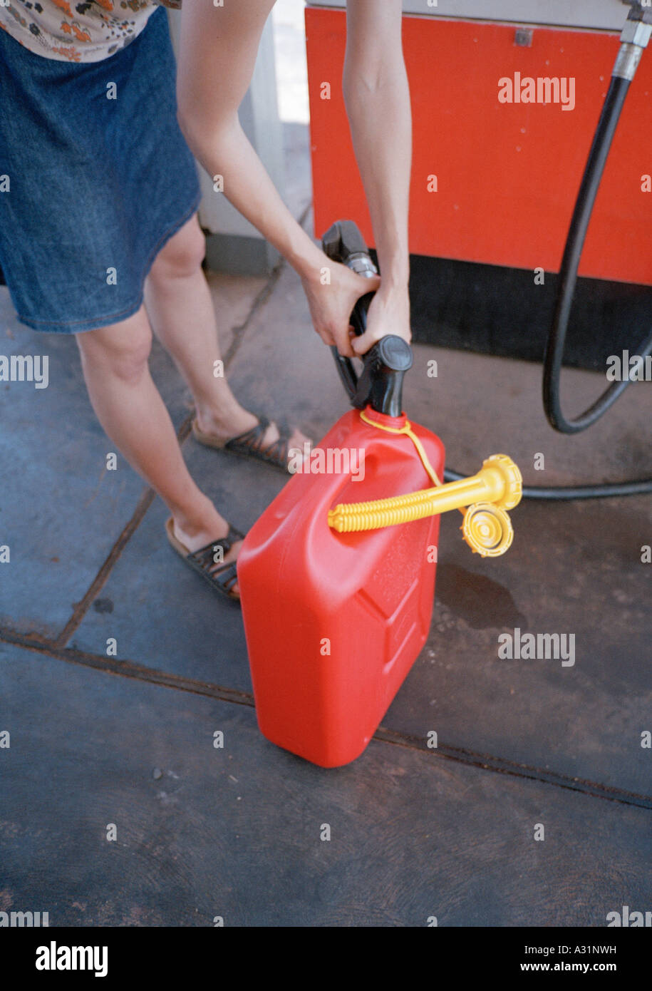 Donna gas di riempimento può essere a gas station Foto Stock