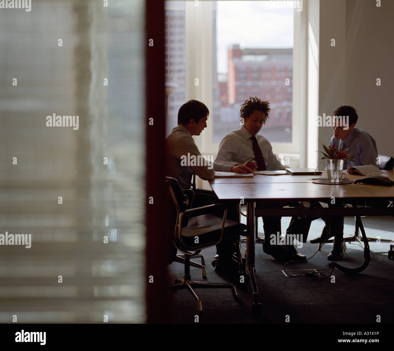 Tre uomini di affari riuniti nella sala conferenze Foto Stock