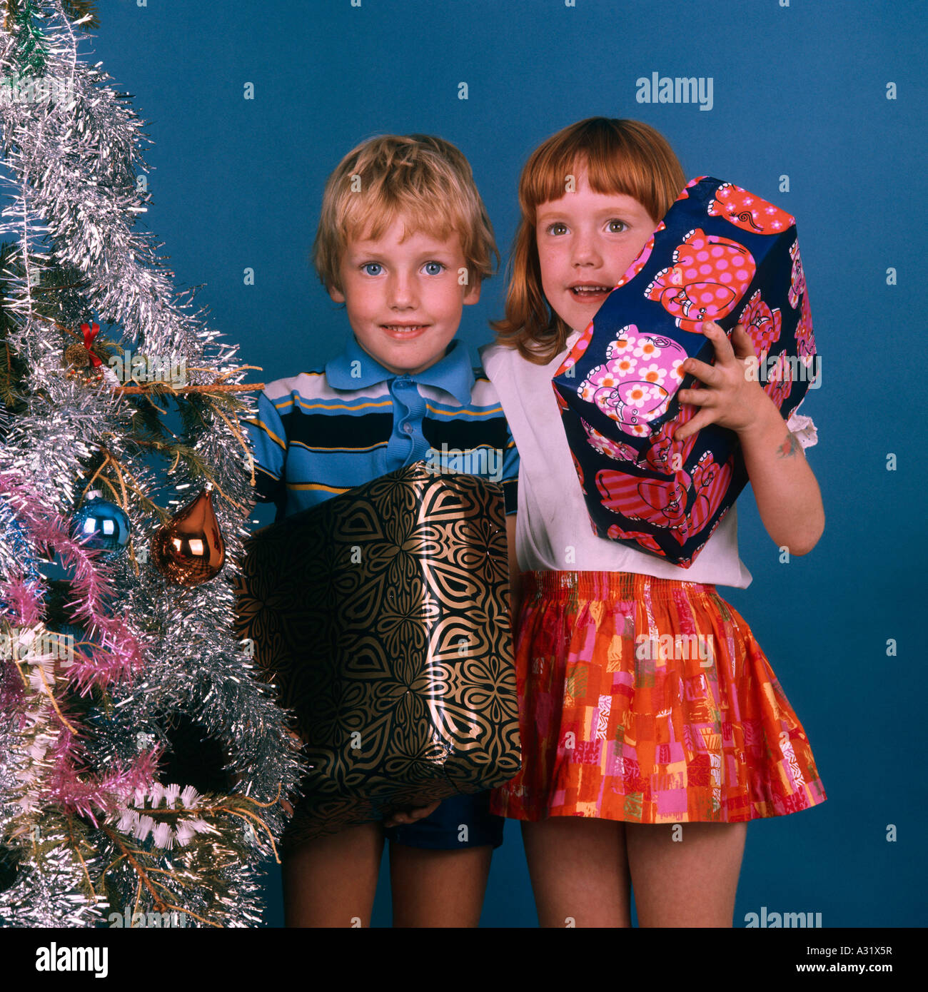 Bambini con albero di Natale e regali - retro 1970 - originale Foto Stock