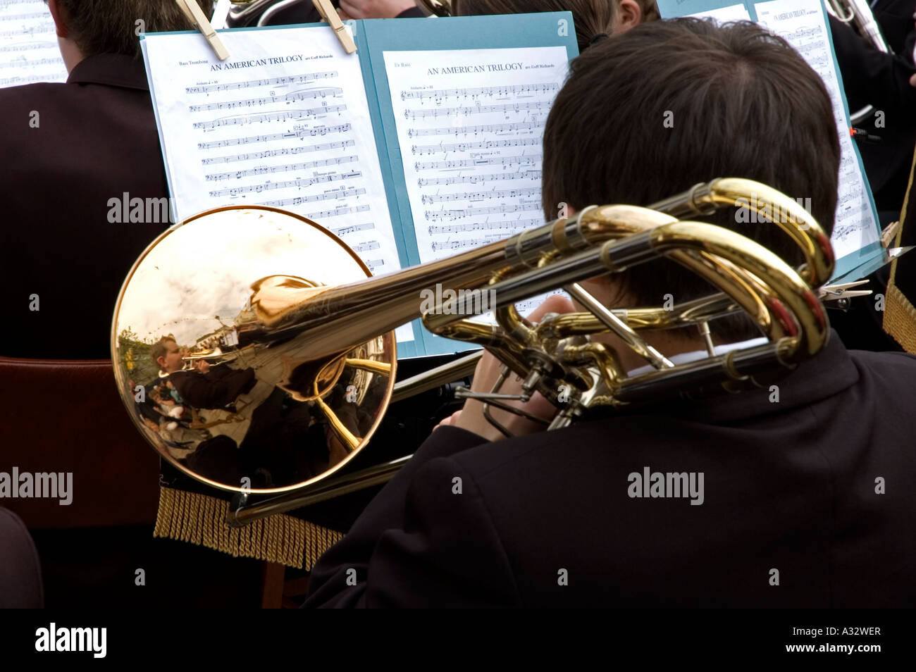 Un giovane musicista che gioca il trombone in un argento/banda di ottoni Foto Stock
