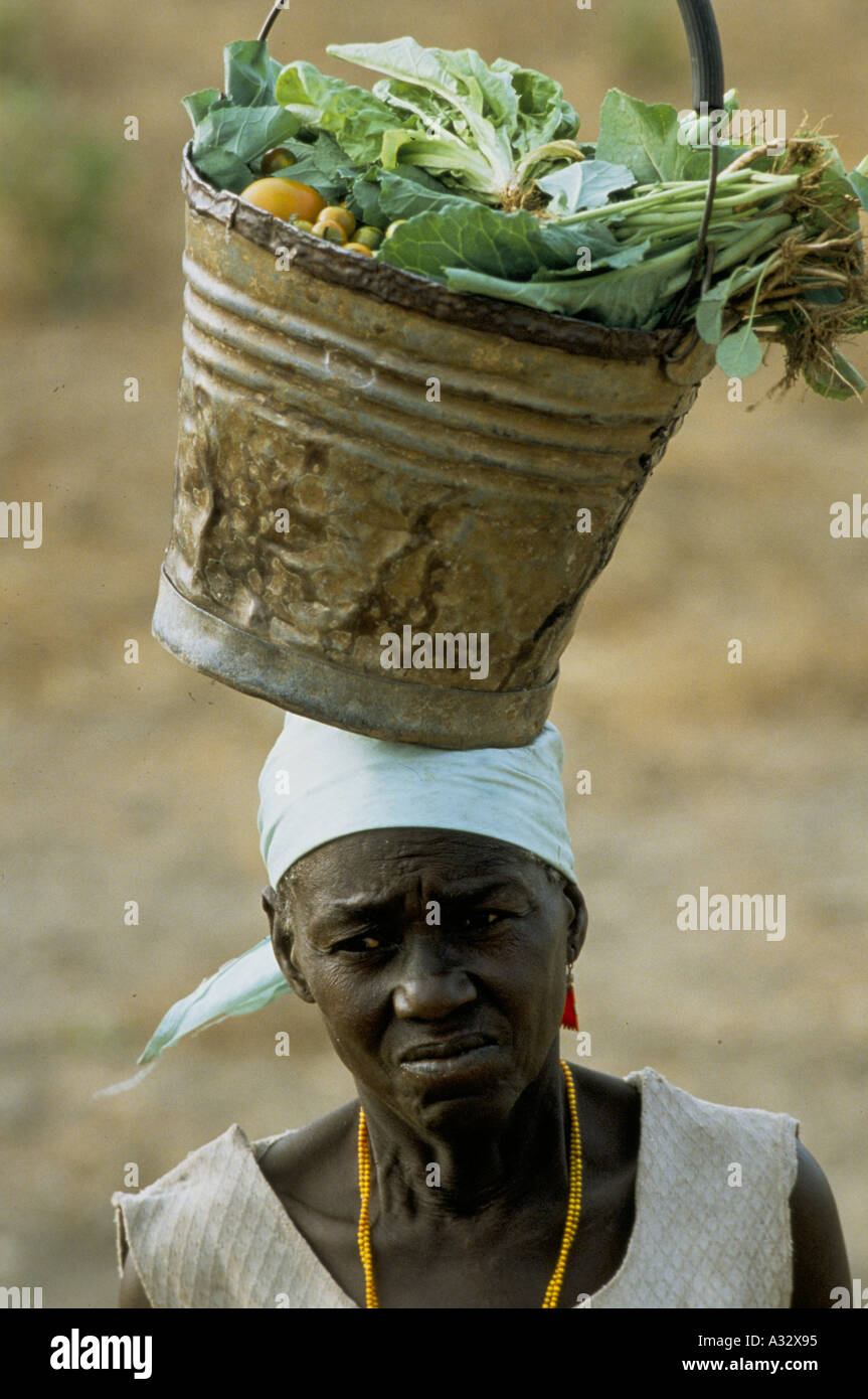 Finemente equilibrata, una donna porta un secchio di verdure sul suo capo, Zambia 1992 Foto Stock