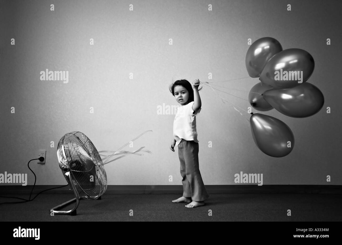 Bambino tiene palloncini di fronte alla ventola Foto Stock