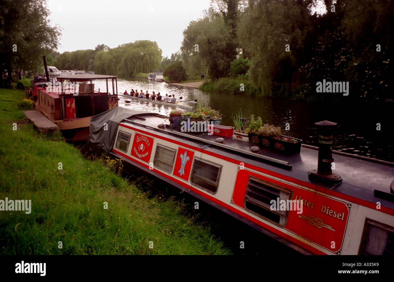 I rematori su una università womens equipaggio del team fila passato case galleggianti sul fiume Cam in Cambridge Inghilterra England Foto Stock