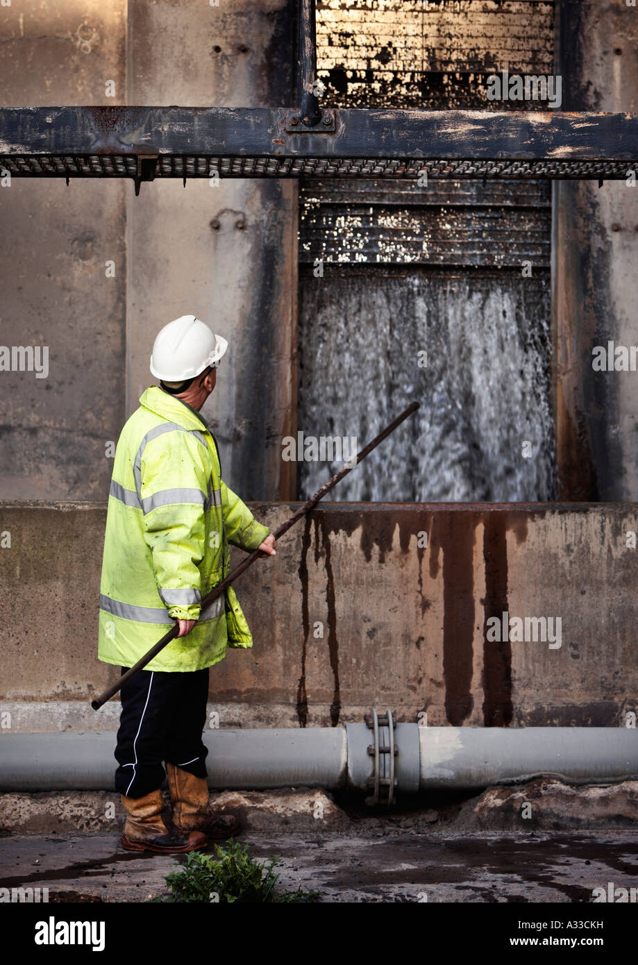 Workman regolando le paratoie dei rifiuti di cenere box di lavaggio in corrispondenza di un Coal Fired power station NEL REGNO UNITO Foto Stock