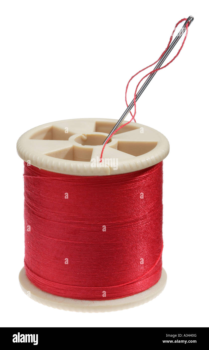 Bobina di cotone con filo rosso e ago di cucitura Foto Stock