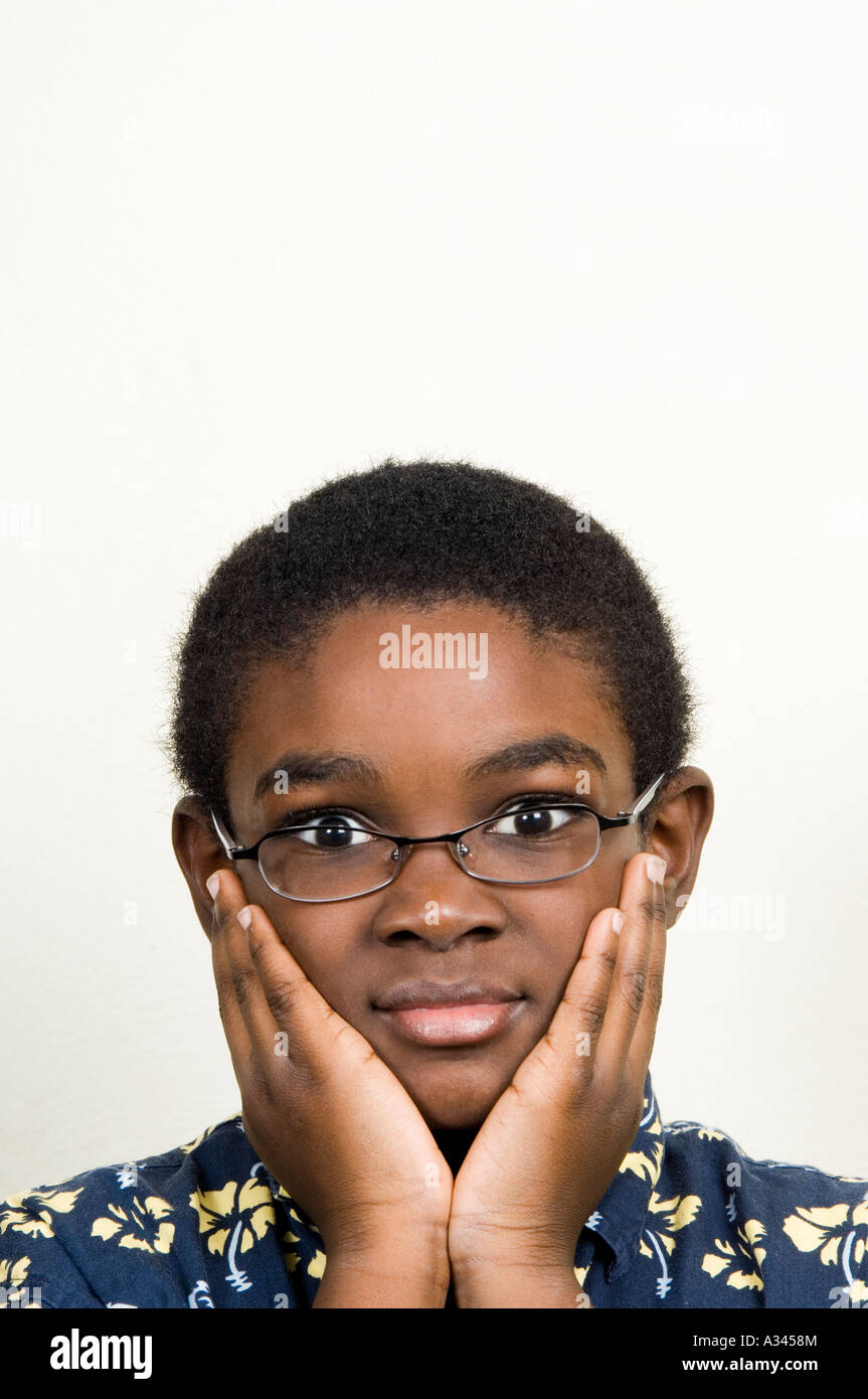 Ritratto di un giovane americano africano ragazzo con la testa tra le mani Foto Stock