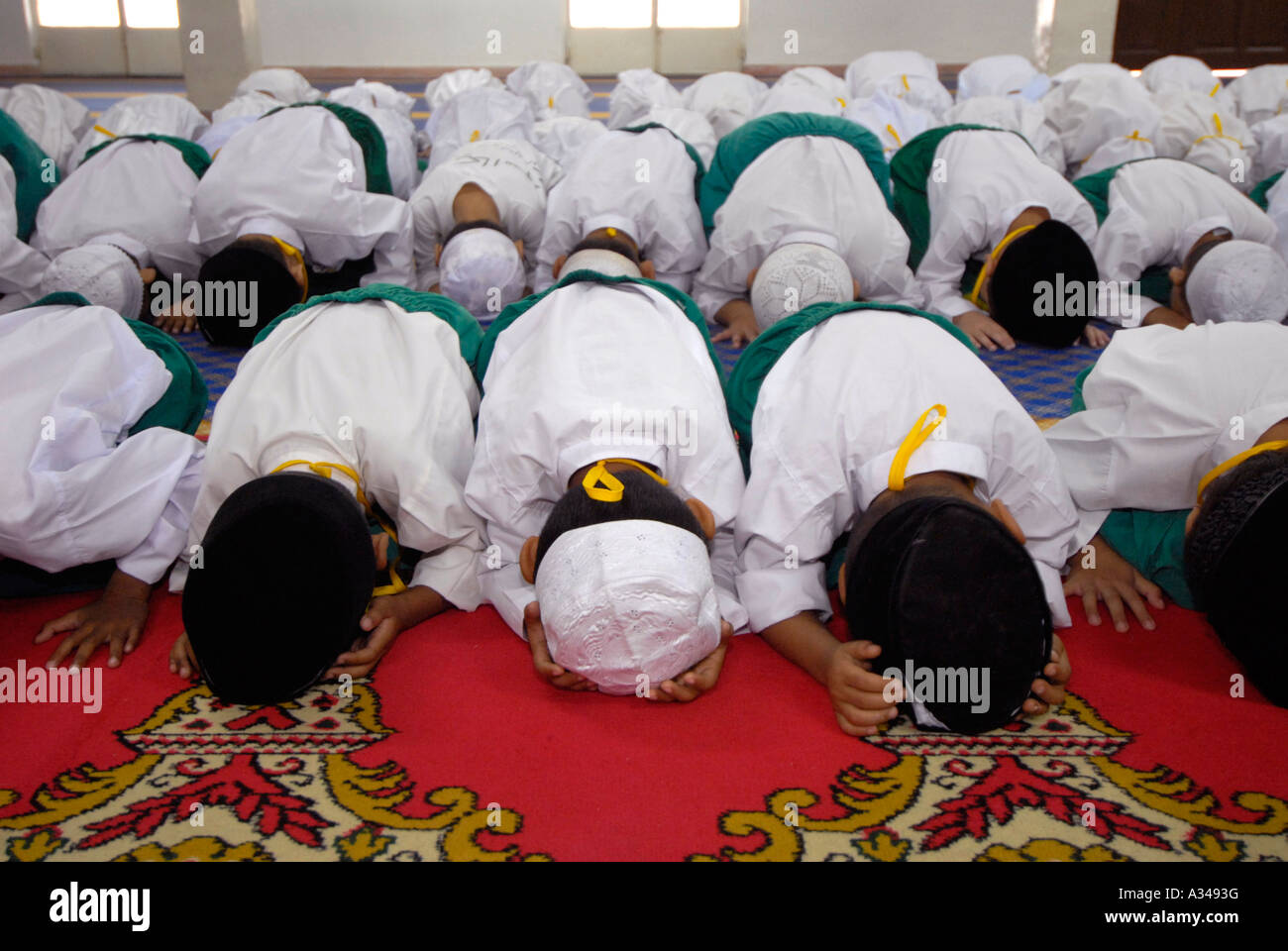 Livello primario di un asilo nido e gli studenti durante il momento di preghiera in una moschea, Foto Stock