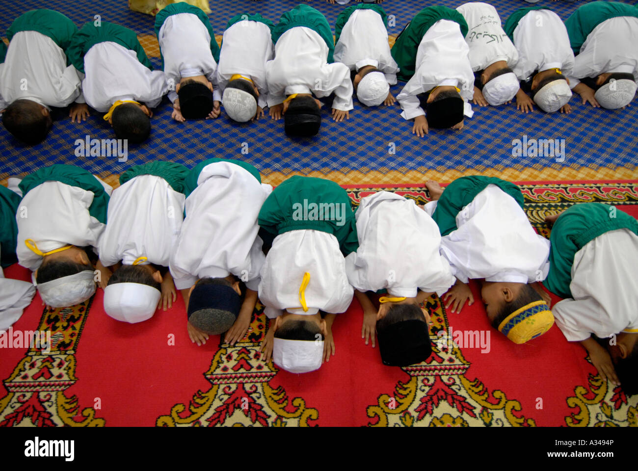 Livello primario di un asilo nido e gli studenti durante il momento di preghiera in una moschea, Kuala Lumpur, Malesia Foto Stock