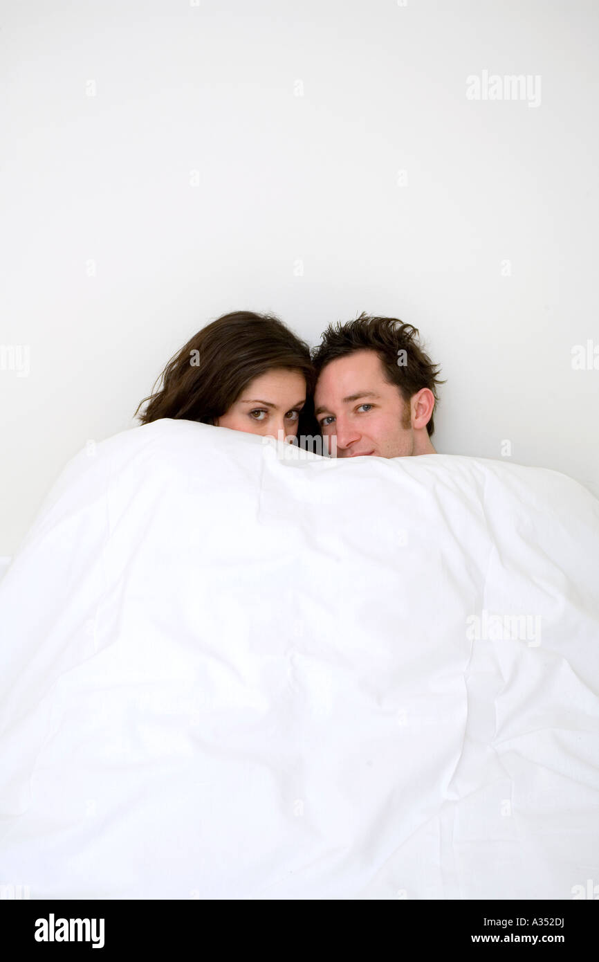 Coppia giovane accogliente e caldo sotto un piumone nel letto Foto stock -  Alamy