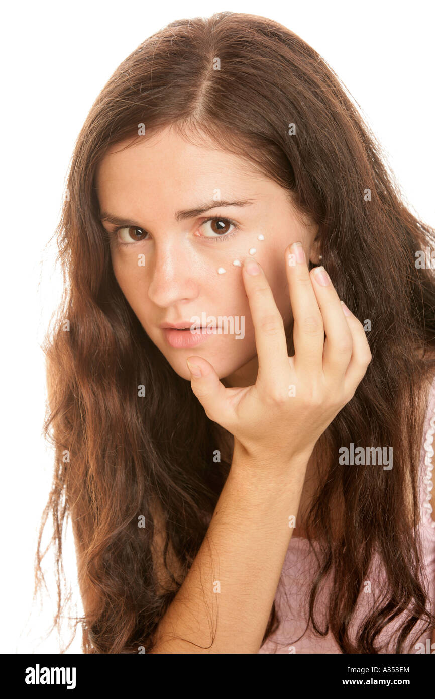 Giovane donna mettendo crema contorno occhi su Foto Stock