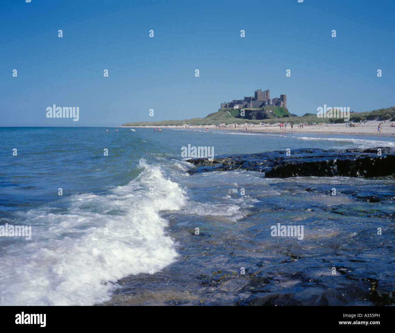 Il castello di bamburgh visto sopra la spiaggia, bamburgh, Northumberland, Inghilterra, Regno Unito. Foto Stock