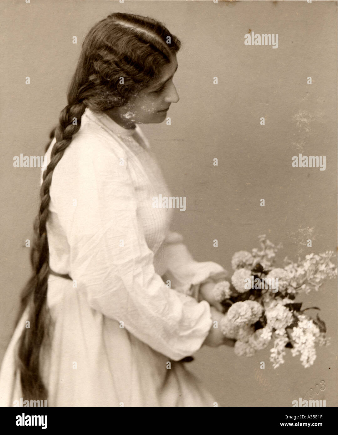 Foto storiche di una donna nell'anno 1900 fiori mazzetto i peli lunghi pigtail Foto Stock
