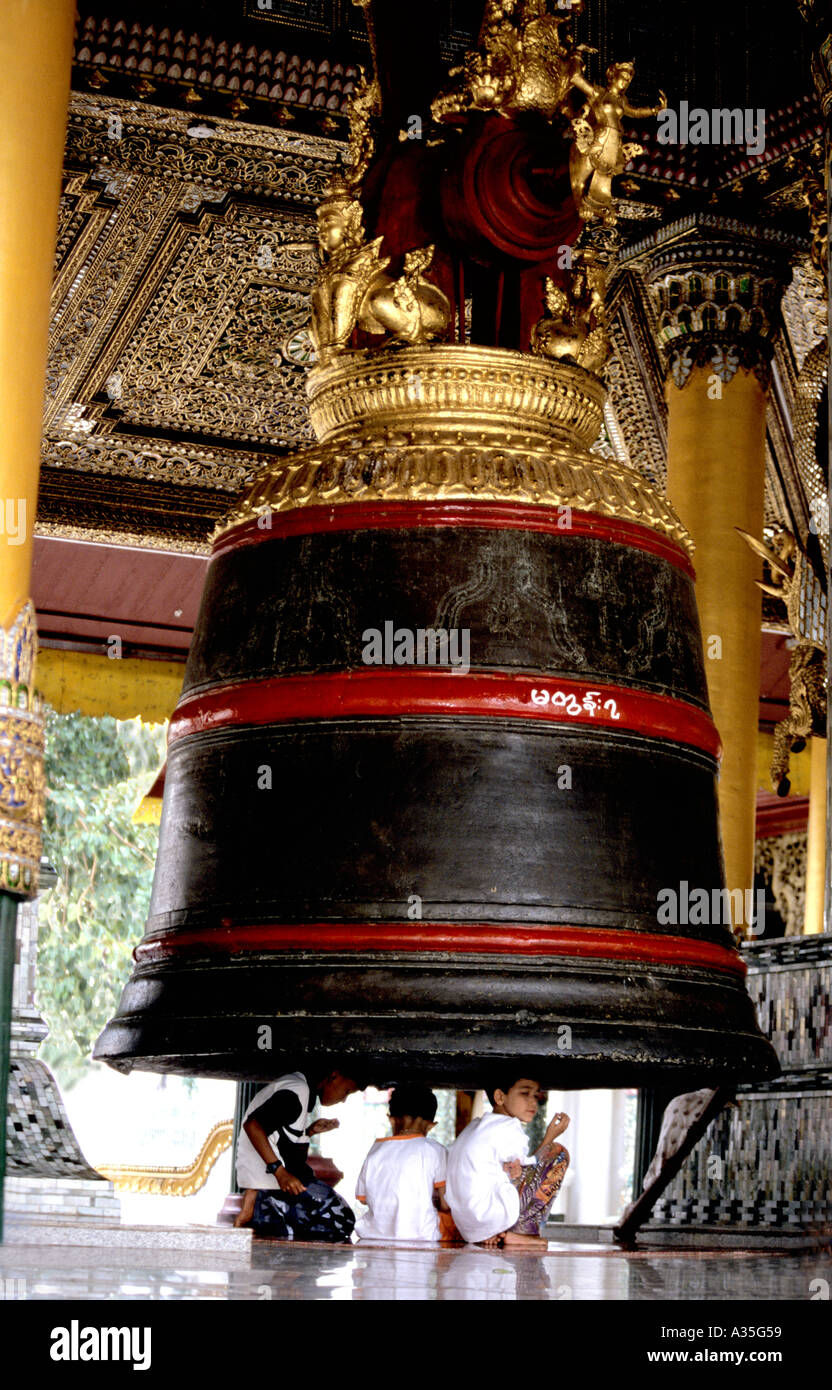 Bambini attendere sotto Shwedagon pagoda grande campana per il suono quando viene colpito è atto di fede. Foto Stock